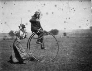Man on a penny-farthing bicycle being chased by his sister (Maggie & Bob Spiers) - West Wyalong, NSW, Circa 1900, in the collection of the Museum of NSW.